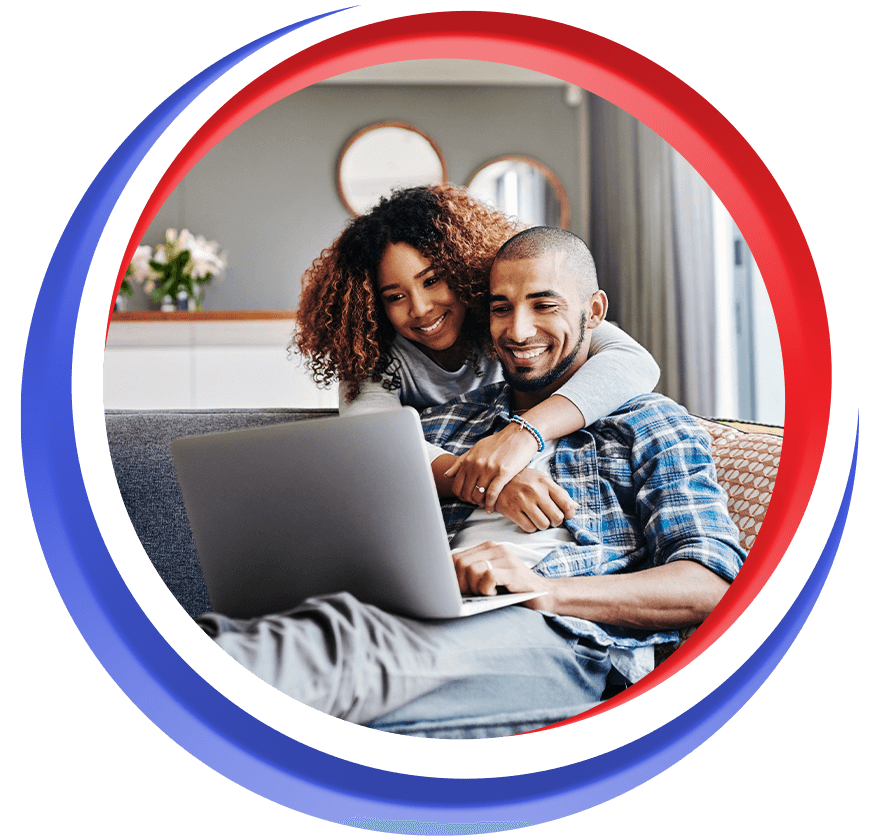 Couple smiling while looking at a laptop together Couple smiling while looking at a laptop together
